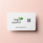 Carte professionnelle de Trèfle et Papillon sur fond rose pâle, avec logo, code QR et adresse du site web